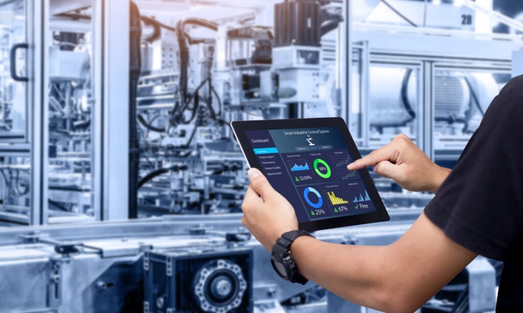 A man with a digital tablet in a manufacturing plant.