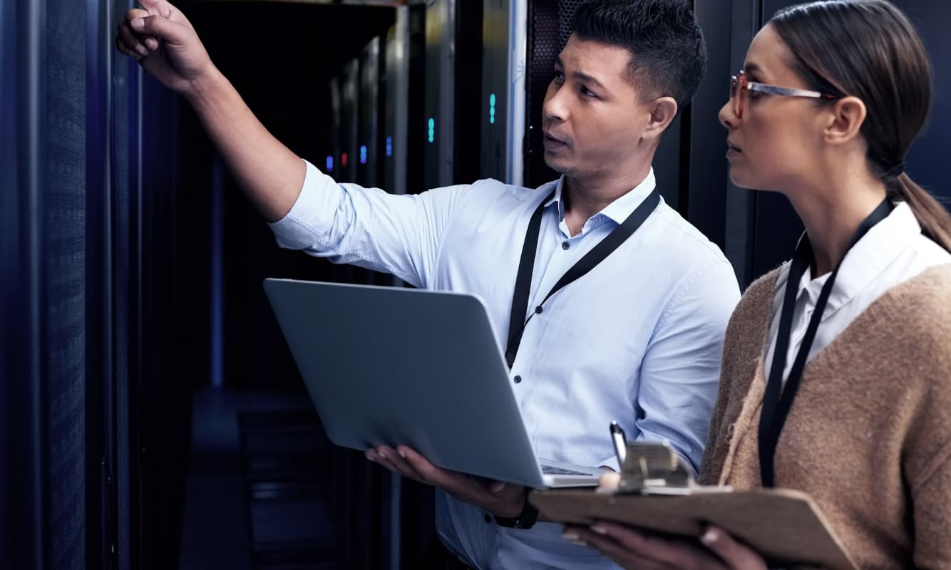 Two IT support members conducting routine cloud infrastructure maintenance.