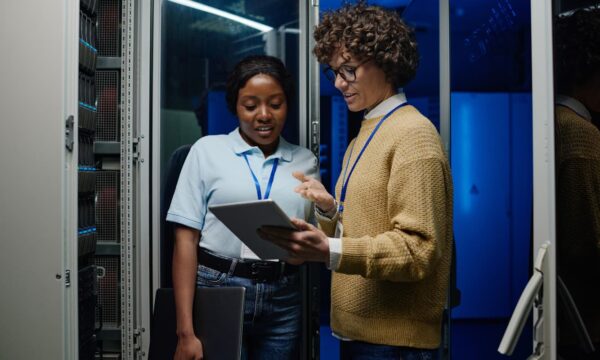 Two IT heads in a data center discussing where to move data and applications.