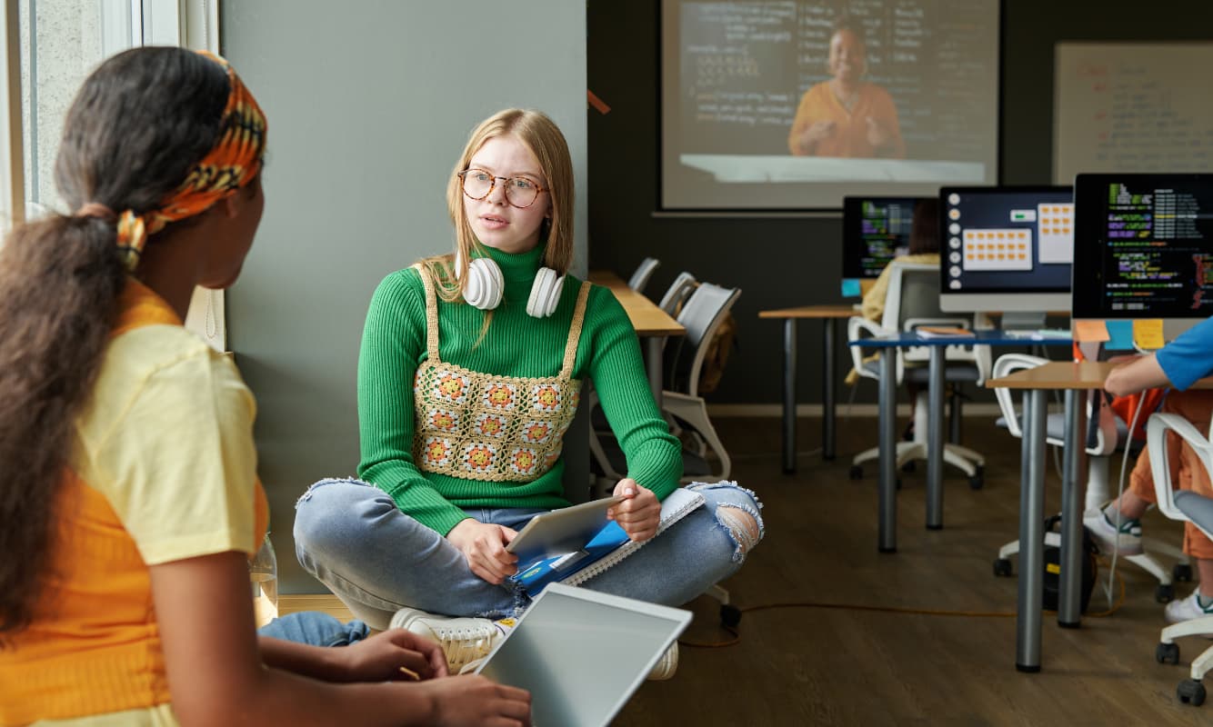 Two students enjoy a modern classroom shaped by AI.